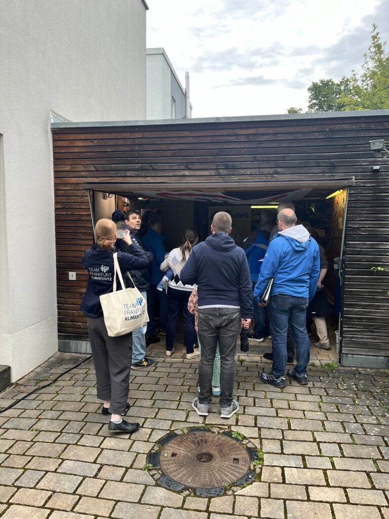 Menschen, die vor einer Garage stehen und zuhören.